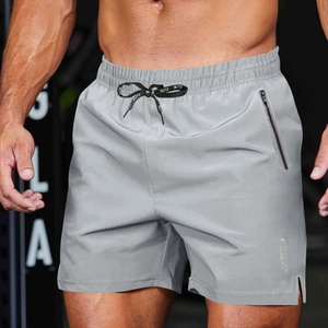 Detail of men's athletic shorts with zipper pocket, drawstring waist, and side slit