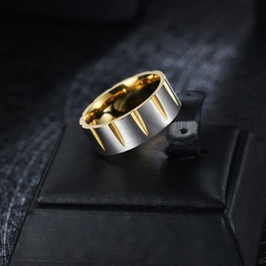 Macro shot of two-tone stainless steel ring with silver brushed finish and golden V-cut detail