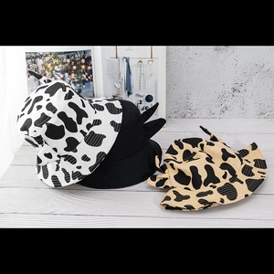 Detail shot of cotton bucket hats with cute horns in cow print and solid black designs
