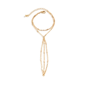 Detailed view of gold pearl hand chain bracelet with lobster clasp on white background