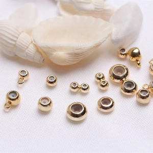 Macro view of 14k gold-filled beads with silicone core insert on white shell decor
