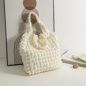 Close-up of cream textured bubble waffle fabric on a large capacity shoulder tote bag