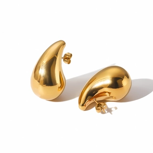 Detailed macro view of hollow teardrop earrings with a high-polished gold mirror finish