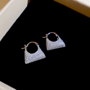 Macro detail of silver square zircon hoop earrings in a black velvet jewelry box