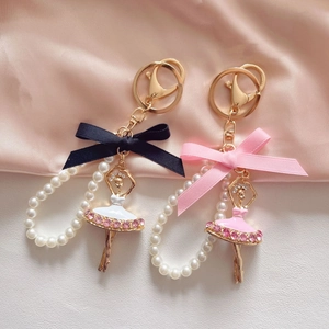 Detail of ballet girl keychains with rhinestones, pearls, and colorful silk bows