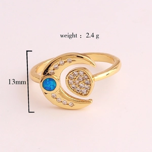 Detailed view of gold moon ring with blue opal and small white zircons, 13mm width