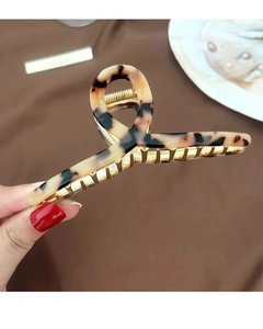 Close-up of tortoise shell pattern claw clip with gold metal teeth for thick hair