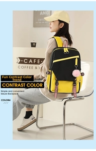 Detail of black and yellow casual backpack with SPORT strap and pink pompom pendant