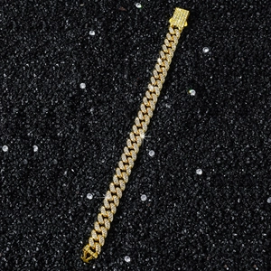 Close-up of 10mm gold Cuban chain link bracelet with pavé rhinestones on black stones