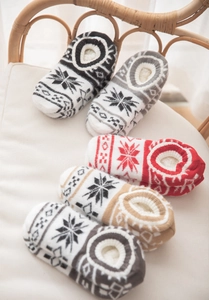 Detailed close-up of colorful Nordic snowflake knitted socks with warm plush lining