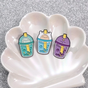 Set of 3 cartoon bubble tea enamel pins in mint, blue, and lilac on a shell tray