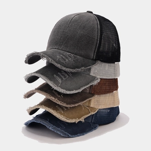Pila di cinque cappelli trucker vintage consumati in vari colori neutri con rete traspirante