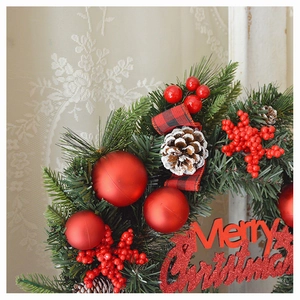 Detail von Weihnachtskranz mit roten Beeren, Zapfen und Merry Christmas Schild