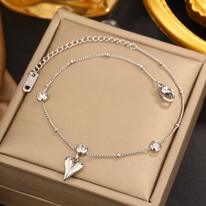 Detail of silver heart charm bracelet with round stones and K18 tag on jewelry box