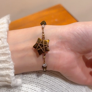 Close-up of a handmade bohemian woven bracelet with star-shaped tiger eye stone and crystals