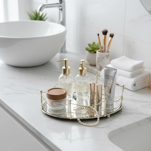 Round geometric mirrored vanity tray with golden metal fence on white marble countertop