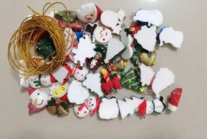 Detailed macro view of assorted resin Christmas charms and gold cord in a clear storage box