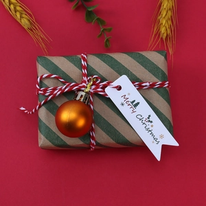 Dettaglio del cartellino Merry Christmas su scatola regalo con nastro e decorazioni