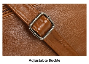 Detail of adjustable metal buckle and textured brown lychee leather on a crossbody bag