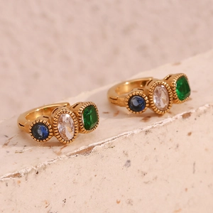 Macro view of 18K gold plated hoop earrings with blue, white, and green gemstones