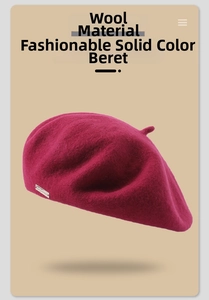 Detailed close-up of dark burgundy wool beret fabric texture with small metal logo