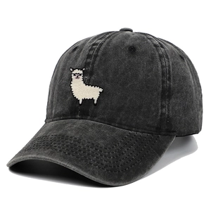 Detail of white alpaca embroidery on washed black cotton baseball cap with reinforced visor