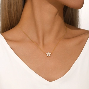 Close-up of a gold s925 silver necklace featuring a five-petal flower crystal pendant