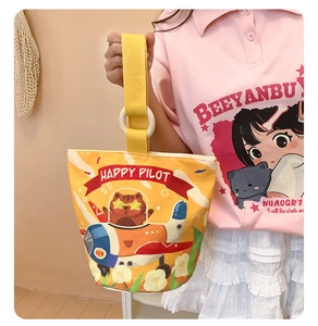 Detail of yellow canvas bucket bag showing fabric handles and cute pilot cat illustration