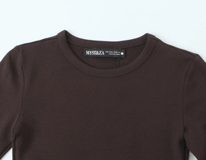 Détail du t-shirt marron foncé à manches longues montrant le col rond et l'étiquette