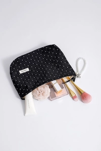 Detailed interior view of a large capacity polka dot cosmetic bag with makeup items