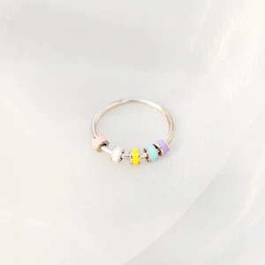 Detail of colorful enamel sliding beads on an S925 silver anxiety ring for women