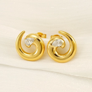 Detailed view of vintage gold-plated spiral earrings with pear-cut zircon insets on silk