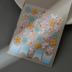 Detailed macro of 3D embossed floral nail stickers featuring pink and yellow hibiscus flowers