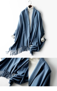 Detail of blue wool scarf with fringe and soft texture on white ribbed sweater