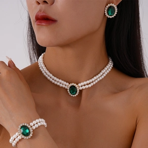 Three-piece jewelry set with white pearls, green oval stones, and sparkling rhinestones