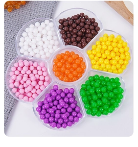 Close-up of colorful resin beads in a clear flower-shaped seven-grid storage tray