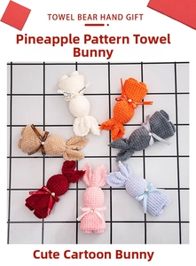 Detail of waffle fabric towels folded into bunnies with ribbons and pearls in seven colors