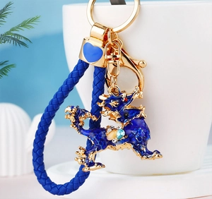 Detailed close-up of Kirin keychain with blue enamel, teardrop gems, and braided rope