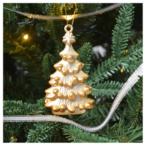 Close-up of a golden Christmas tree hanging ornament with textured finish on a festive branch