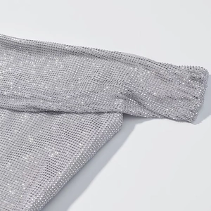 Détail rapproché du tissu en maille strass argentée scintillante sur le haut élégant