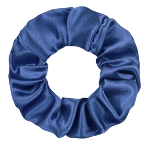 Detailed view of the dark blue satin scrunchie showing smooth texture and silky shine