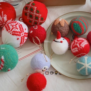 Close-up of knitted red and white wool felt Christmas balls and snowman tree ornaments