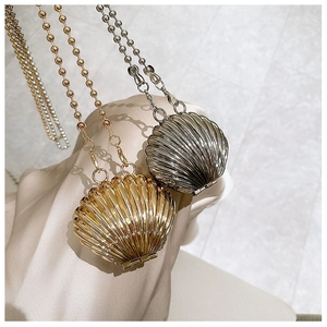 Close-up of mini shell-shaped metal evening bags with beaded chains in gold and silver