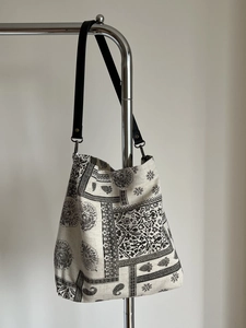 Close-up of mandala floral print tote bag with black leather straps and metal rings