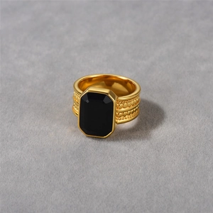 Primer plano de un anillo vintage bañado en oro de 18k con ónix negro y textura tejida