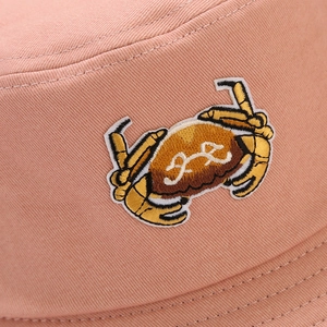 Macro detail of high-quality pink twill cotton fabric with 3D crab embroidery