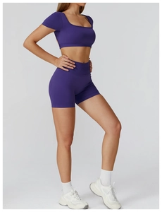 Detail of dark purple seamless yoga set with high-waist shorts and short sleeve crop top