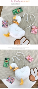 Detail of soft white plush goose bag with orange plaid scarf and adjustable strap