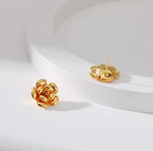 Macro view of detailed 3D gold-plated brass flower earrings with layered petals
