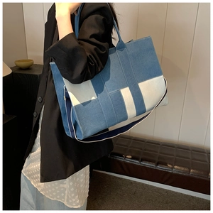 Detail of blue denim patchwork tote bag with striped detachable shoulder strap